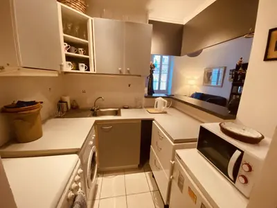 a white kitchen with a sink and a dishwasher at 2 bedroom apartment in the heart of Cannes air conditioning easy walk to the Palais des Festivals - 2015 in Cannes