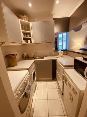 a kitchen with white cabinets and a dishwasher at 2 bedroom apartment in the heart of Cannes air conditioning easy walk to the Palais des Festivals - 2015 in Cannes