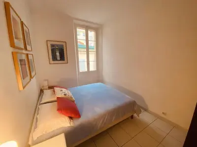 a small bedroom with a bed with a window at 2 bedroom apartment in the heart of Cannes air conditioning easy walk to the Palais des Festivals - 2015 in Cannes
