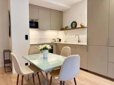 a kitchen and dining room with a glass table and chairs at Luxueux 3 pièces - 2 chambres avec Terrasse, 4 mn Palais in Cannes