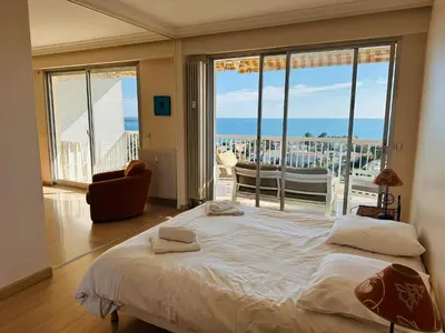 a bedroom with a bed with a view of the ocean at Large, light and modern 2 bedroomed apartment in Cannes with Sea Views, pool and lovely terrace - 1503 in Cannes