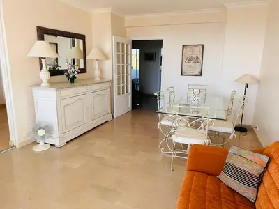a living room with a glass table and chairs at Large, light and modern 2 bedroomed apartment in Cannes with Sea Views, pool and lovely terrace - 1503 in Cannes