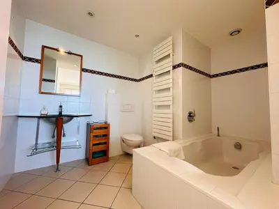a bathroom with a tub and a toilet and a sink at Large, light and modern 2 bedroomed apartment in Cannes with Sea Views, pool and lovely terrace - 1503 in Cannes