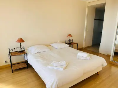 a bedroom with a large white bed with towels on it at Large, light and modern 2 bedroomed apartment in Cannes with Sea Views, pool and lovely terrace - 1503 in Cannes