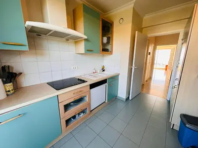 a kitchen with green and white cabinets and a sink at Large, light and modern 2 bedroomed apartment in Cannes with Sea Views, pool and lovely terrace - 1503 in Cannes