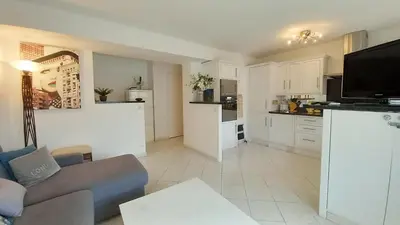 a living room with a couch and a kitchen at Le Fragonard in Cannes
