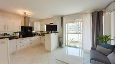 a kitchen with white cabinets and a large window at Le Fragonard in Cannes
