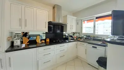 a kitchen with white cabinets and a black counter top at Le Fragonard in Cannes