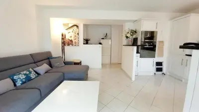 a living room with a couch and a kitchen at Le Fragonard in Cannes