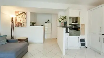a living room with a couch and a kitchen at Le Fragonard in Cannes