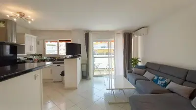 a kitchen and a living room with a couch and a table at Le Fragonard in Cannes