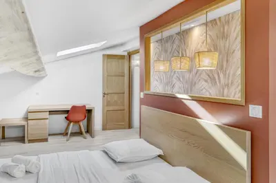 a bedroom with a bed and a desk and a red chair at 2 Bed - Ascenseur - 2 min du Palais - Climatisé in Cannes