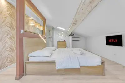 a bedroom with a bed with a clock on the wall at 2 Bed - Ascenseur - 2 min du Palais - Climatisé in Cannes