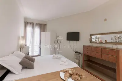 a bedroom with a white bed and a television at Palais Miramar - Suite & E37 - 20M Plage - Croisette Emplacement Unique - WIFI - Clim in Cannes