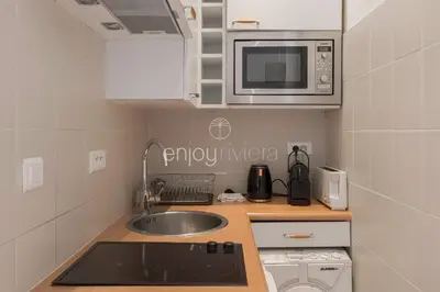 a small kitchen with a sink and a microwave at Palais Miramar - Suite & G17 - Vue Mer - Croisette Emplacement Unique -20 Plage - WIFI - Clim in Cannes