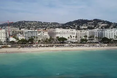 a view of a beach with buildings and the ocean at Palais Miramar - Suite & G17 - Vue Mer - Croisette Emplacement Unique -20 Plage - WIFI - Clim in Cannes