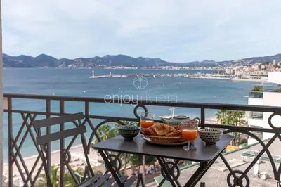 a table with a basket of bread and two glasses of orange juice at Palais Miramar - Suite & G17 - Vue Mer - Croisette Emplacement Unique -20 Plage - WIFI - Clim in Cannes