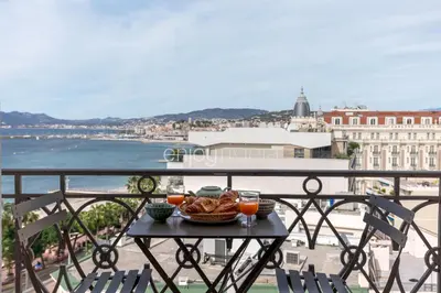 a table with a bowl of food on a balcony at Palais Miramar - Suite & G17 - Vue Mer - Croisette Emplacement Unique -20 Plage - WIFI - Clim in Cannes