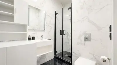 a white bathroom with a shower and a sink at Le Riviera by Winsome Destination in Cannes