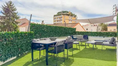 a patio with tables and chairs on the grass at Le Riviera by Winsome Destination in Cannes