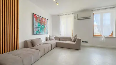 a living room with a couch and two windows at Le Riviera by Winsome Destination in Cannes