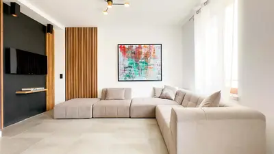 a living room with a couch and a tv at Le Riviera by Winsome Destination in Cannes