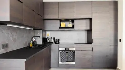 a kitchen with wooden cabinets and a sink and a stove at Le Riviera by Winsome Destination in Cannes