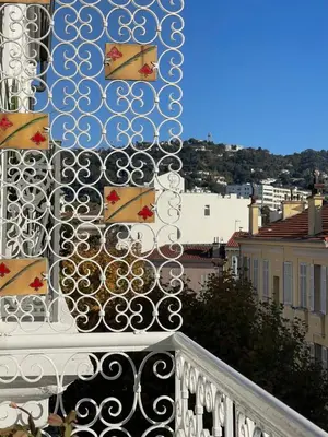 a balcony with a railing with flags on it at CENTRAL CANNES in Cannes