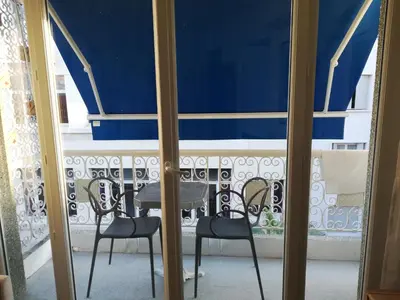 a table and chairs in a room with a window at CENTRAL CANNES in Cannes