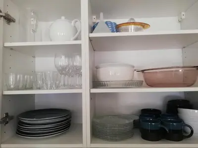 a white pantry with plates and dishes on shelves at CENTRAL CANNES in Cannes