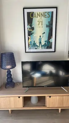 a television on a wooden entertainment center with a picture at CENTRAL CANNES in Cannes