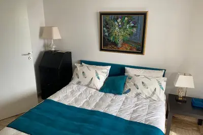 a bedroom with a bed with a blue and white comforter at Sea View & Large Terrace LIVE IN LA VISTA in Cannes