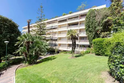 an apartment building with a lawn in front of it at Le Gallia haven of peace in the city center with Terrace GALLIA LYS in Cannes