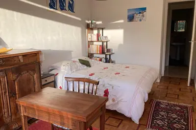 a bedroom with a bed and a table in it at Le Gallia haven of peace in the city center with Terrace GALLIA LYS in Cannes