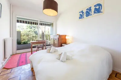 a bedroom with a large white bed with two towels at Le Gallia haven of peace in the city center with Terrace GALLIA LYS in Cannes