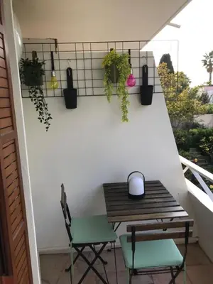 a balcony with a wooden table and two chairs at Design studio terrace and beach LIVE IN MARLYNE in Cannes
