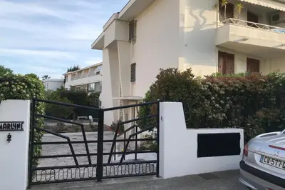 a white building with a black gate and a car at Design studio terrace and beach LIVE IN MARLYNE in Cannes