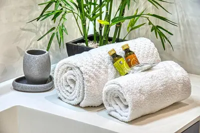 a bathroom with towels and oils on a counter at WE CANNES ! Terrace sea view swimming pool car park Cannes Center in Cannes