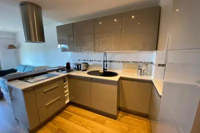 a kitchen with white cabinets and a sink in it at WE CANNES ! Terrace sea view swimming pool car park Cannes Center in Cannes