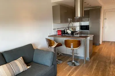 a living room with a couch and a kitchen at WE CANNES ! Terrace sea view swimming pool car park Cannes Center in Cannes