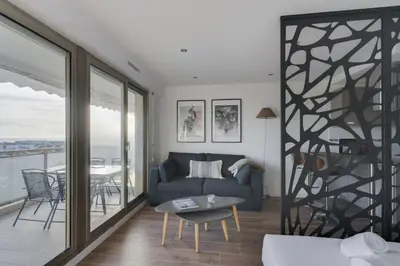 a living room with a couch and a table at WE CANNES ! Terrace sea view swimming pool car park Cannes Center in Cannes