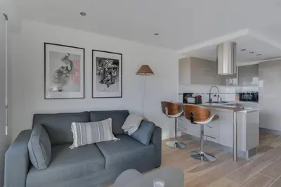 a living room with a couch and a kitchen at WE CANNES ! Terrace sea view swimming pool car park Cannes Center in Cannes