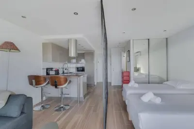 a room with a bed and a kitchen and a couch at WE CANNES ! Terrace sea view swimming pool car park Cannes Center in Cannes