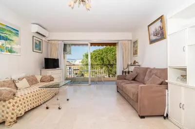 a living room with a couch and a tv at Cosy Studio Cannes Center beaches shopping and congresses LIVE IN MERLE in Cannes
