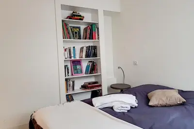 a bedroom with a bed and a book shelf with books at Sublime Apartment Center Croisette LIVE IN Moliere in Cannes