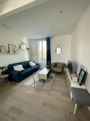 a living room with a blue couch and a table at Superbe 2 pièces lumineux - Cannes Gare in Cannes
