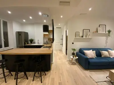 a kitchen and a living room with a blue couch at Superbe 2 pièces lumineux - Cannes Gare in Cannes