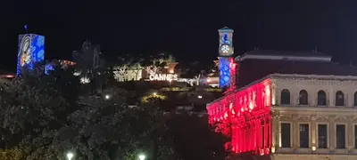 a building with a clock tower with red and blue lights at Cannes suquet Croisette in Cannes