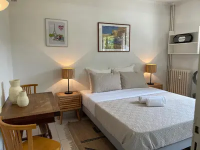 a bedroom with a bed and a desk with two lamps at Cannes 100 mètres de la plage, entièrement climatisé in Cannes