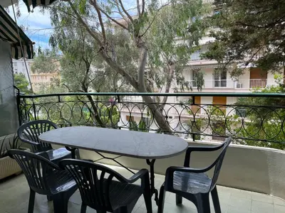 a table and chairs sitting on a balcony at Cannes 100 mètres de la plage, entièrement climatisé in Cannes